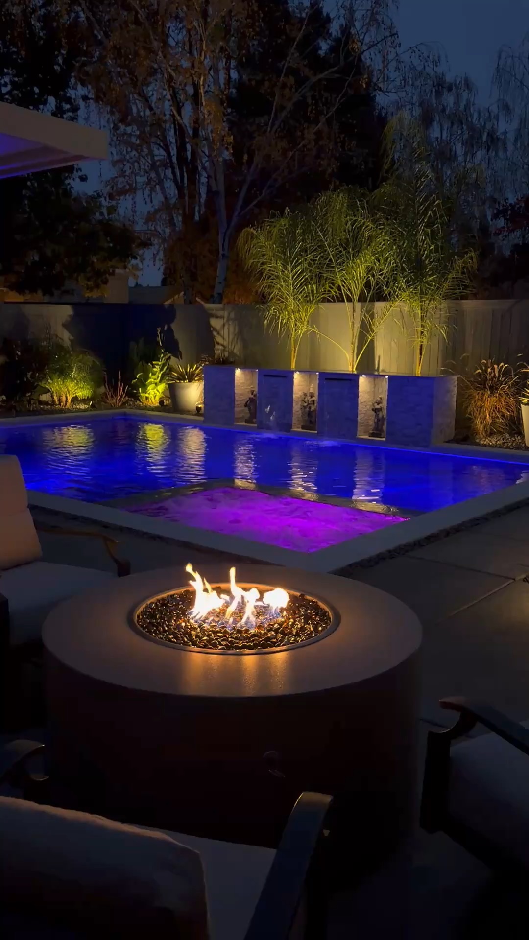 Custom pool with fire pit and landscape lighting by CJR