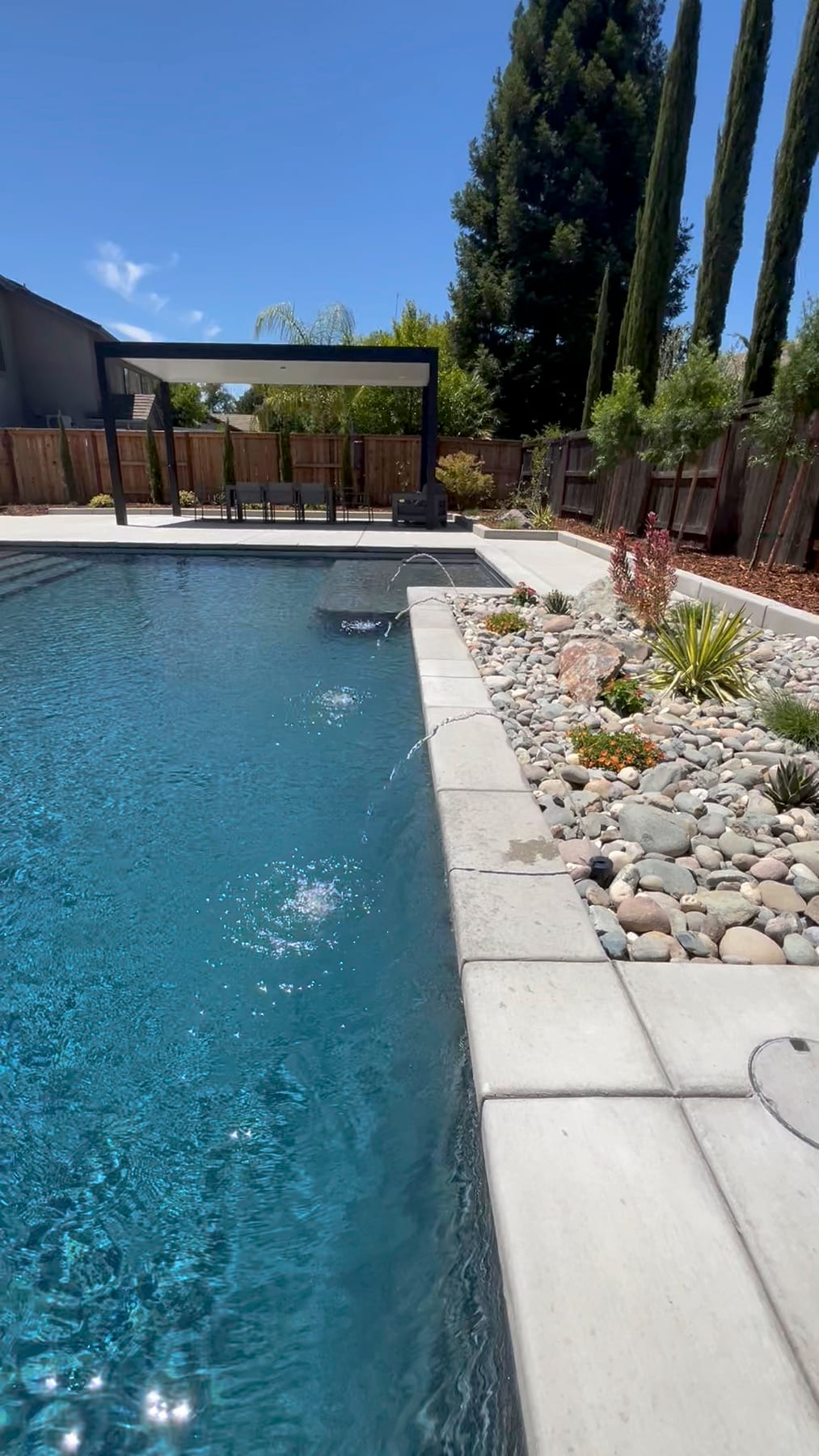 Custom pool with pergola and rock landscaping built by CJR in the greater Sacramento area