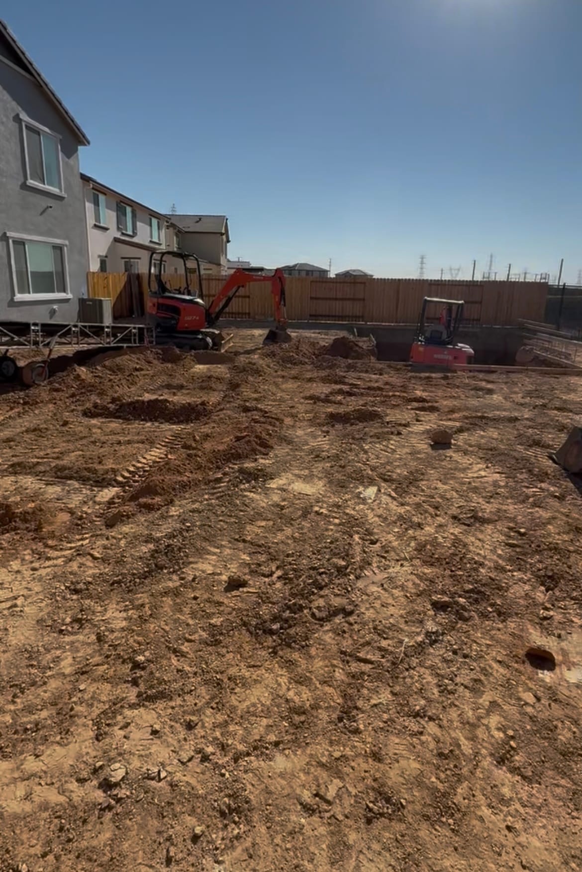 Excavator digging a custom pool during the excavation phase