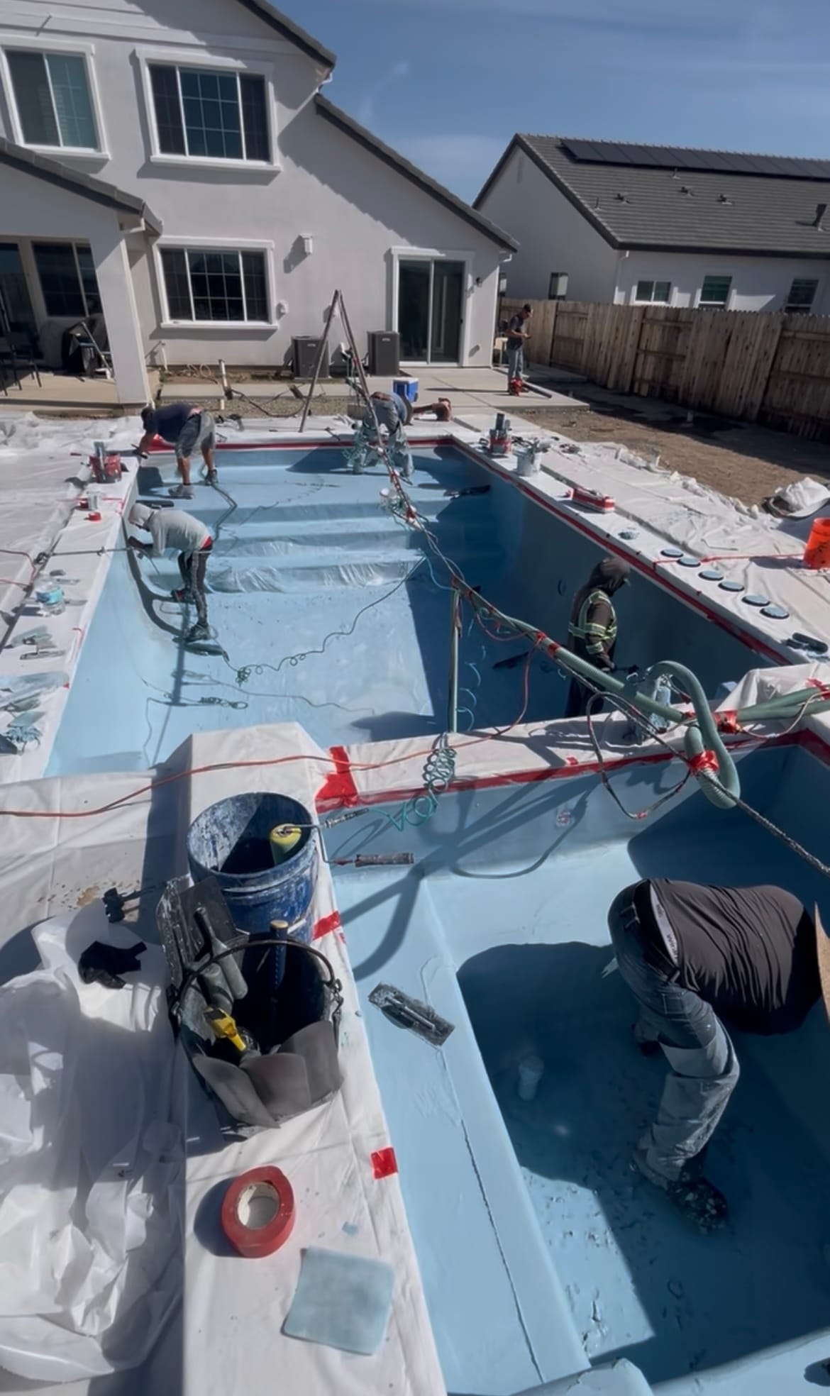 Crew hand-troweling pool plaster for a smooth interior finish
