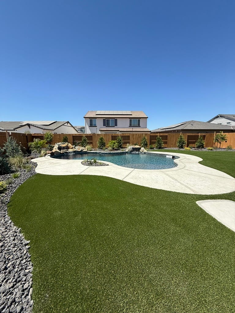 Completed backyard with pool, artificial turf, and outdoor living space