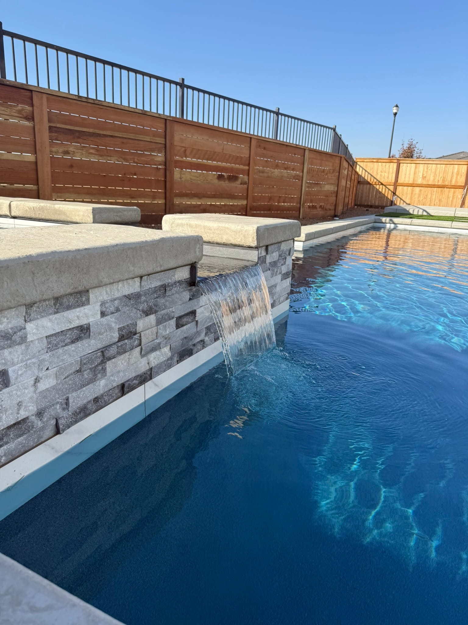 Finished CJR pool with stacked-stone spa wall, ready for the new owners
